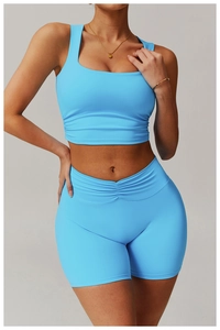 Front view of blue two-piece workout set with ruched cropped top and V-cross high waist shorts