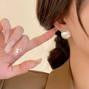 Chic matte white pearl stud earrings on model for a minimalist luxury look