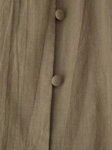 Macro view of brown cotton-linen fabric texture with matching fabric-covered buttons