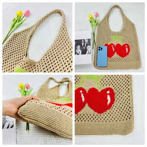 Detail view of khaki knit tote bag with red cherry patterns and sturdy handle texture