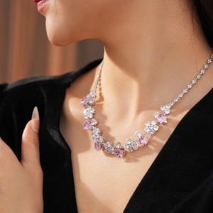 Close-up of pink and white zircon flower necklace on a model with elegant black velvet