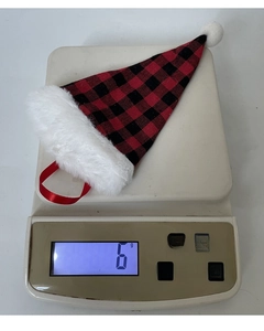 Mini red plaid Christmas hat decoration weighing 6g on an electronic scale for cutlery