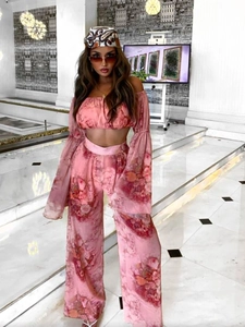 Pink floral two-piece set featuring off-shoulder long sleeve top and wide-leg trousers