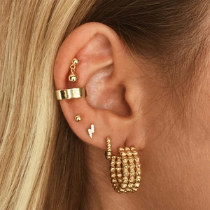 Set of gold S925 sterling silver star and geometric stud earrings on a female model