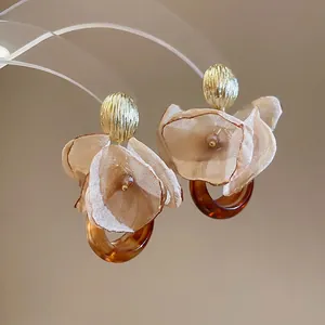 Elegant chiffon flower earrings with amber resin hoop on transparent stand