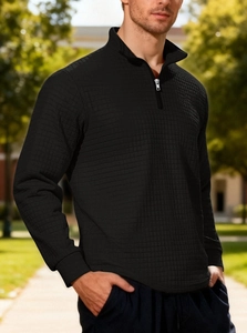 Detail of men's black quarter-zip sweatshirt with a textured waffle knit pattern fabric