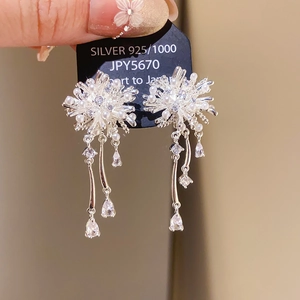 Detail of silver long drop floral earrings with sparkling tassels and faux pearls