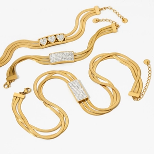 Gold multi-layer snake chain jewelry set with diamond-encrusted heart and bar charms