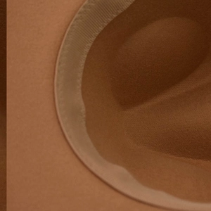 Détail du bandeau intérieur et de la texture en feutre de laine d'un chapeau caramel