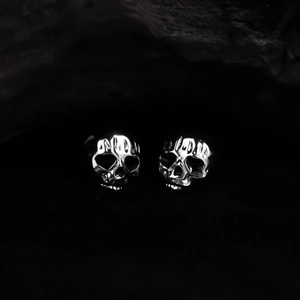 Macro detail of silver skull stud earring with polished finish in a gothic punk style