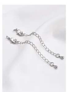 Macro detail of silver extension chains with lobster clasps and teardrop pendants
