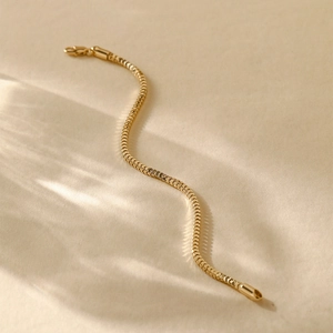 Close-up of 14K gold plated snake chain bracelet with fine polished texture and minimal design