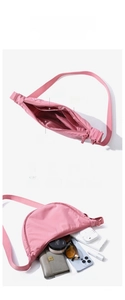 Detail of pink nylon crescent bag interior showing multiple storage pockets and large capacity