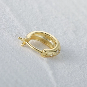 Detailed macro view of S925 sterling silver gold hoop earring with pavé star cubic zirconia