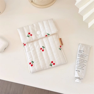Detailed shot of cherry print quilted cotton makeup bag with a snap closure and soft texture