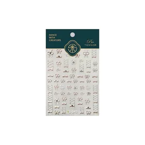 3D embossed champagne bow nail stickers with pearls and rhinestones on packaging