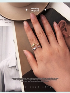 Close-up of cat-shaped adjustable rings in silver and gold with pink heart stones