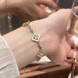Détail macro du bracelet trèfle doré vintage français avec zircons blancs et design ajouré
