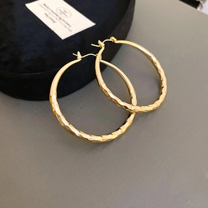 Detailansicht goldener Creolen mit diamantgeschliffener Textur für verbesserten Glanz
