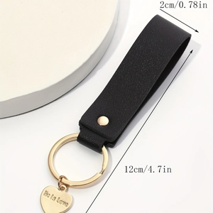 Detail view of black leather heart keychain with He is Love engraving and dimensions