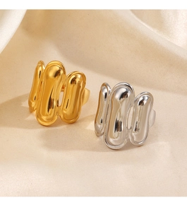 Detailed view of gold and silver plated chunky textured rings on elegant silk fabric