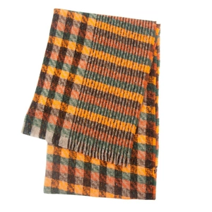Close-up of multicolored plaid scarf with fringe details in orange and green
