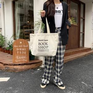 Detail of a beige canvas tote bag with Brick Lane Book Shop print for a casual look