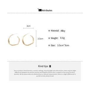 Detail view of irregular geometric golden alloy hoop earrings with product dimensions