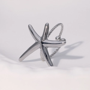 Starfish shaped silver stainless steel ring with textured band on white background