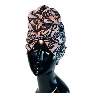 Pink and black faux suede turban featuring vintage vine patterns on a black mannequin