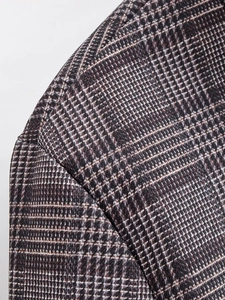 Close-up of houndstooth plaid fabric texture and shoulder stitching on wool coat