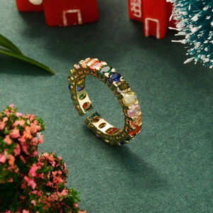 Macro shot of gold star ring with colorful zircon stones on festive green background