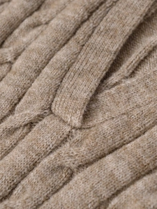Close-up of the thick cable knit texture and high-density stitching on this V-neck polo sweater