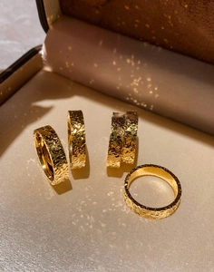 Detailed macro view of 18k gold plated rings featuring unique hammered texture finish