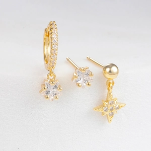 Detailed macro view of a three-piece gold-plated star earring set with cubic zirconia stones
