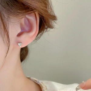 Elegant 4-piece silver heart stud earrings set with sparkling crystals on earlobe