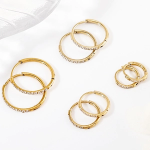 Detailed top view of four pairs of gold-plated hoop earrings set with cubic zirconia stones