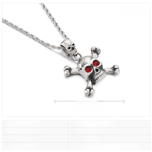 Detailed view of punk style stainless steel skull pendant with red rhinestone eyes