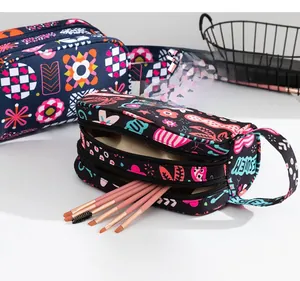 Détail d'une grande trousse de maquillage avec double zip et motifs géométriques