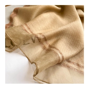 Macro detail of champagne gold silk wool scarf showing metallic woven stripe edges