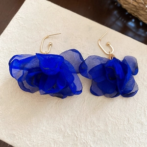 Close-up of royal blue chiffon flower earrings with elegant gold metallic hook detail