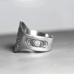 Macro detail of moon phase engraving and stay on it text on brushed silver ring