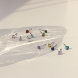Rainbow birthstone stud earrings set in silver claw settings with twelve vibrant colors