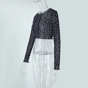 Detail of sheer black polka dot mesh crop top with elegant ruffled lettuce edges