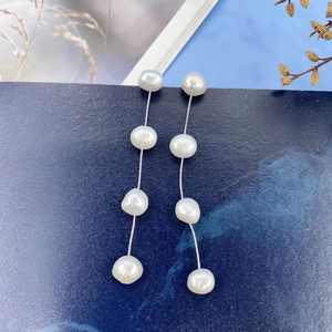 Detail of natural baroque freshwater pearl drop earrings with long silver tassels