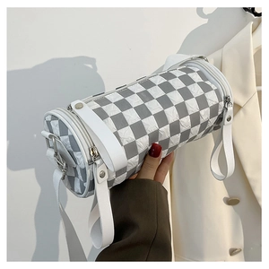 Detail of checkered barrel bag with quilted texture and silver zipper hardware