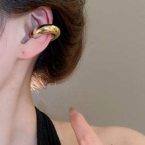 Boucle d'oreille ear cuff dorée polie portée par un mannequin sur le cartilage