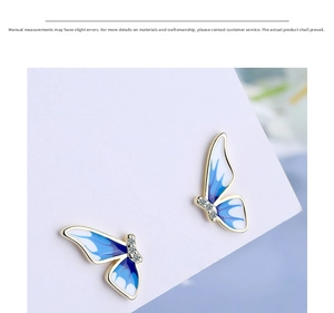 Detailed view of enamel butterfly earrings with blue gradient wings and crystal accents