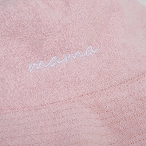 Dettaglio del cappello alla pescatora in spugna rosa con ricamo mama bianco in rilievo