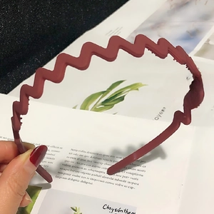Detailed view of dark red wavy headband with inner teeth for secure grip and matte finish